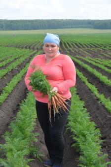 Агроном Ляйсян Миндиярова показывает свежую морковь