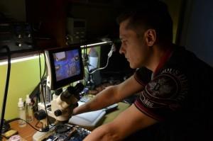 Павел Абоимов рассматривает внутренности ноутбука под микроскопом