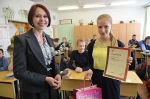 Айгуль Муллаянова награждает Марию Городищенскую на школьном уроке