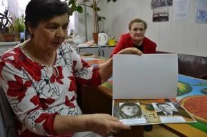 Л. И. Шатунова показывает альбом с портретами погибших воинов