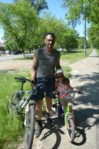 Дмитрий с семилетней дочкой катается на велосипеде