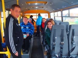 Довольные родители садятся в автобус на места своих детей