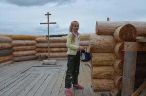 Маша Катунькина покрывает бревна антисептиком